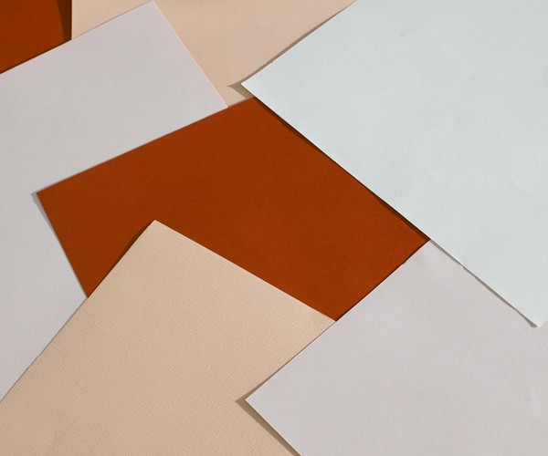 From above of blank paper sheets of different colors scattered on table as abstract background